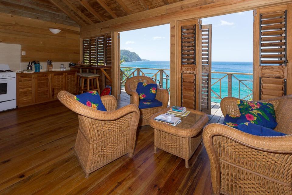 CastaraSeaScape on Heavenly Bay的一间带柳条椅的客厅和一间海景厨房