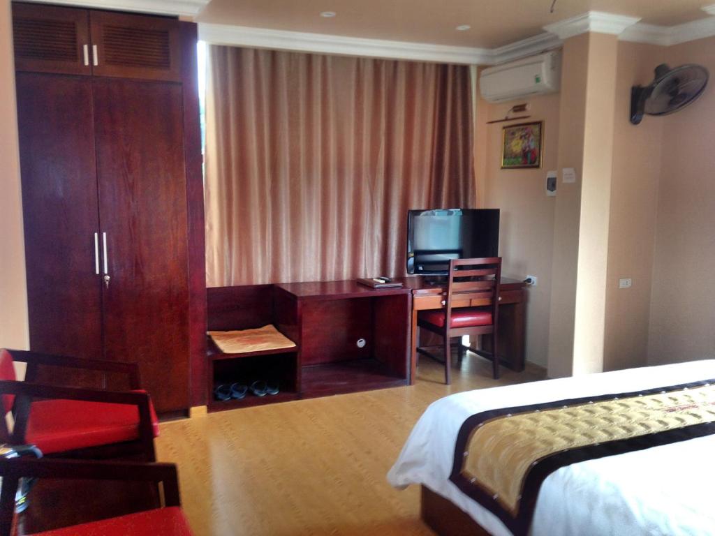 奠边府市宏基精品酒店的酒店客房设有一间带书桌和床的卧室