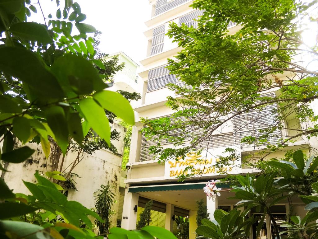 曼谷班西隆第3巷酒店的前面有绿色树木的建筑