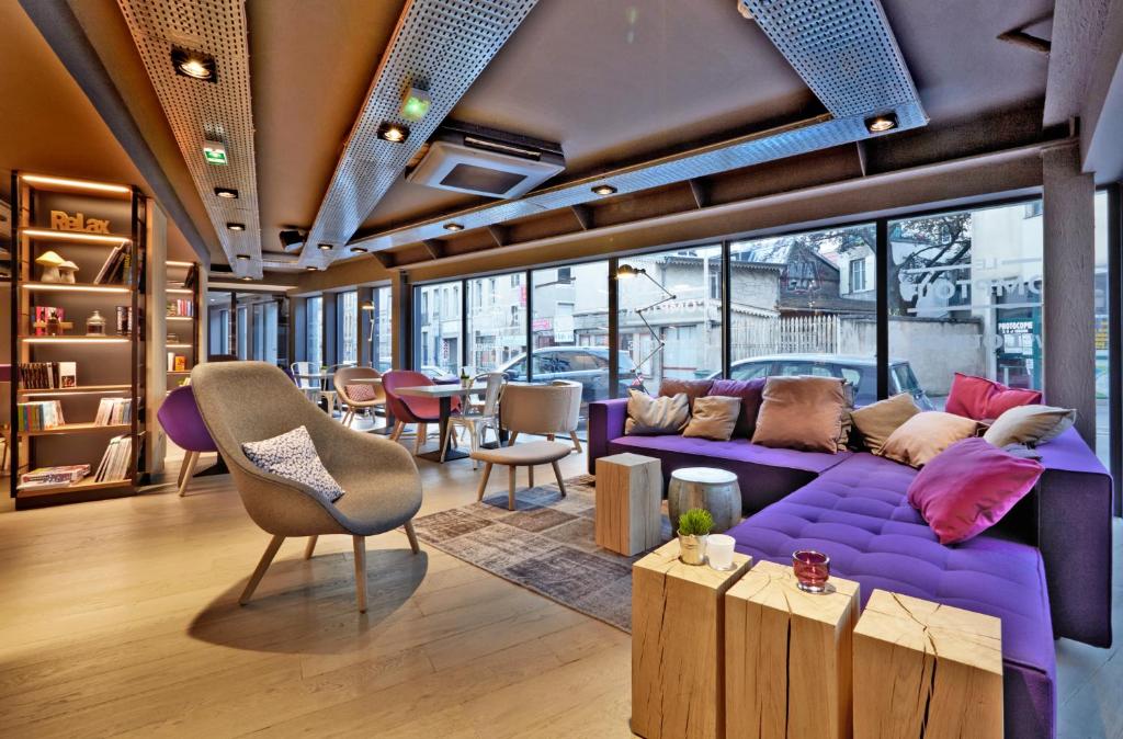 南希南希中心钟楼酒店 - 火车站的客厅配有紫色的沙发、桌子和椅子