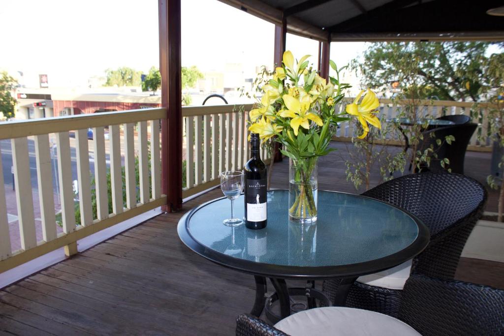 墨累桥第六小屋旅舍的一张桌子,上面放着花瓶和一瓶葡萄酒