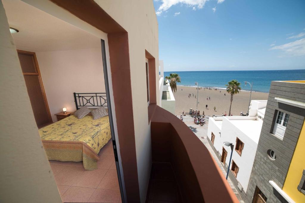 大塔拉哈尔Apartamento con ascensor Gran Tarajal Playa的一间卧室配有一张床,享有海滩美景