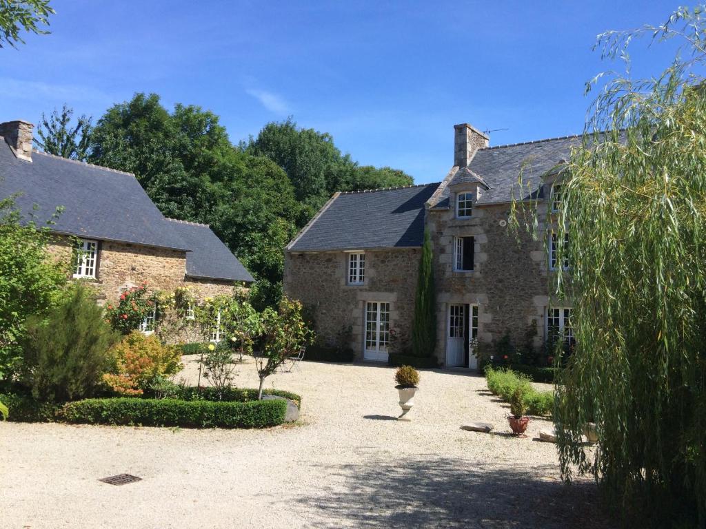 Beaussais sur Mer洛基赖斯查姆Spa住宿加早餐旅馆的一座大型石头房子,前面设有一个庭院