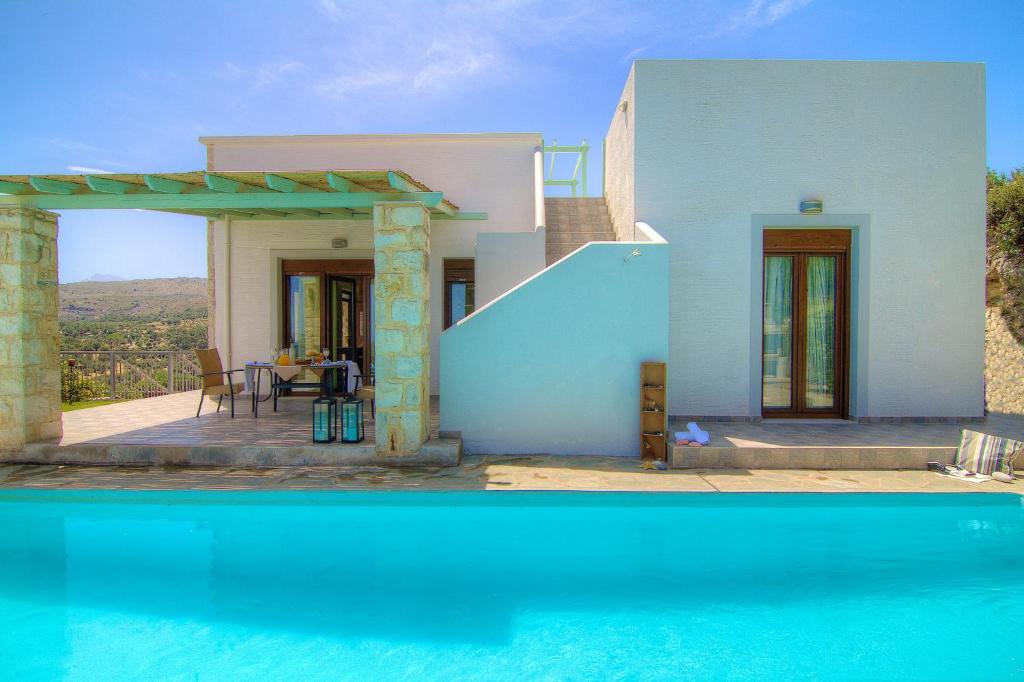 圣特里亚斯Villa Ikaros的一座带游泳池和房子的别墅