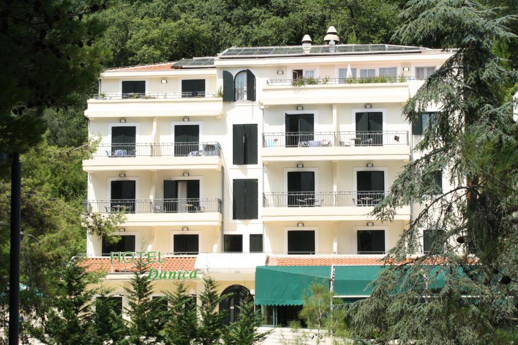 佩特罗瓦纳莫鲁丹妮卡酒店的带阳台和树木的白色建筑