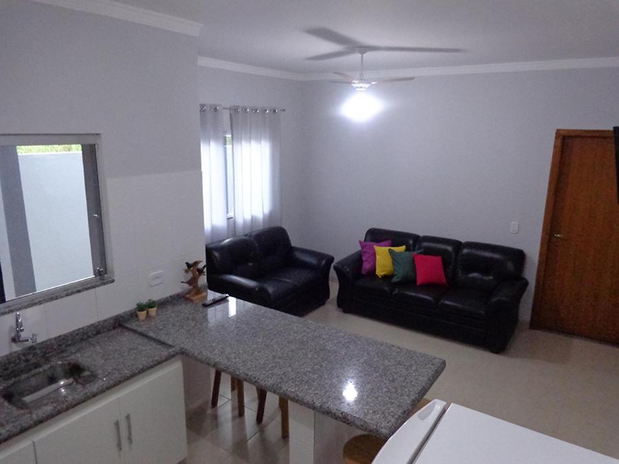 博尼图Casas para temporada em Bonito的厨房以及带沙发和桌子的客厅。