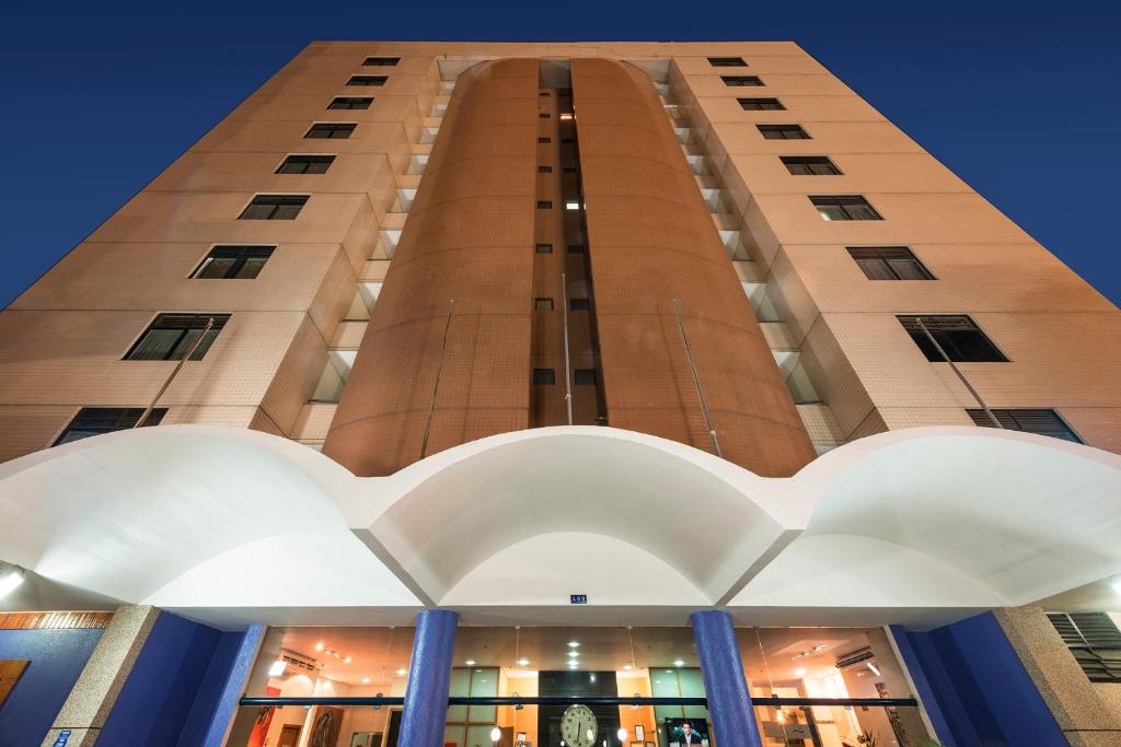 特雷西纳Hotel Executive Arrey的前面有蓝色柱子的高楼