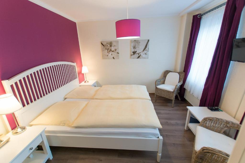 不莱梅Hotel Heldt Dependance的卧室配有白色的床和粉红色的墙壁