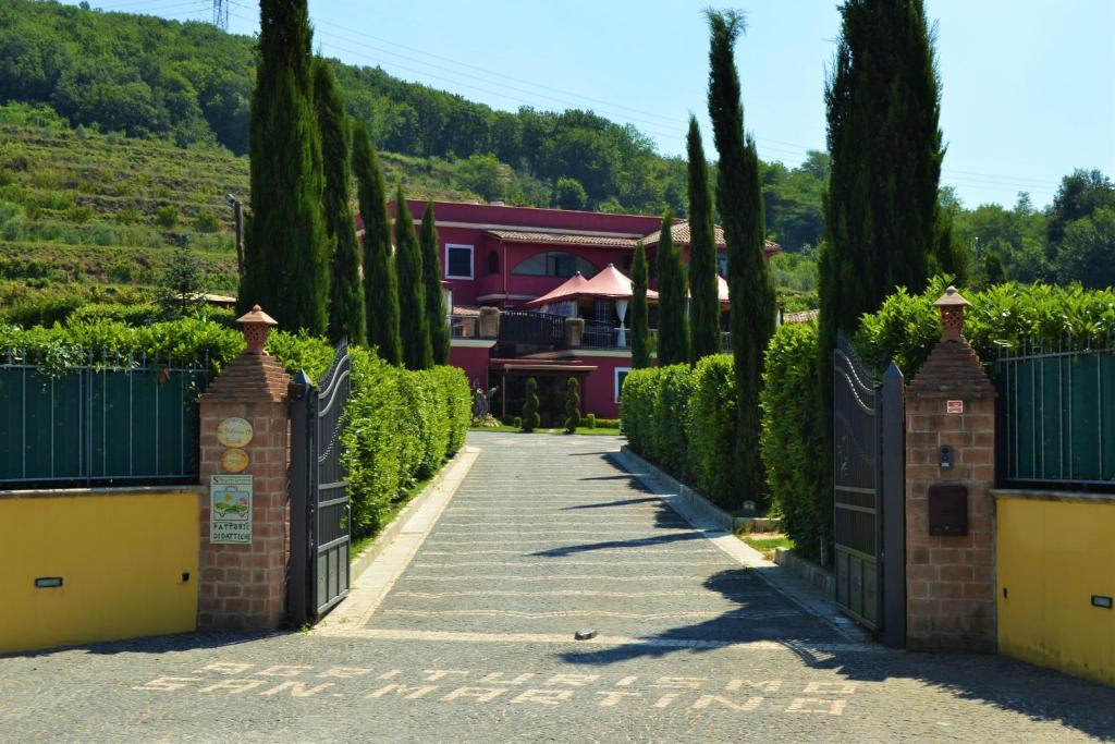 波佐利Agriturismo San Martino的通往有门和树木的房子的车道