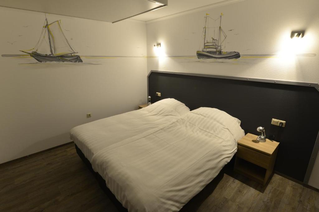 Dinteloord天堂西酒店的卧室配有一张床,墙上有两艘船