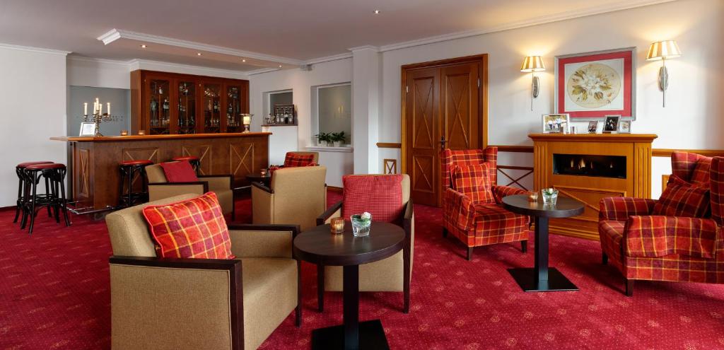 巴特罗森菲尔德德瑞比瑞库恩酒店的酒店大堂设有桌椅和壁炉