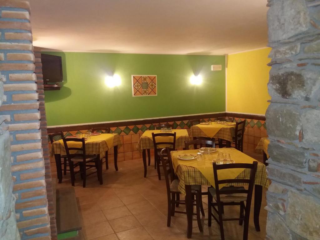 FlorestaHotel Sant'Anna的一间带桌椅和绿色墙壁的用餐室