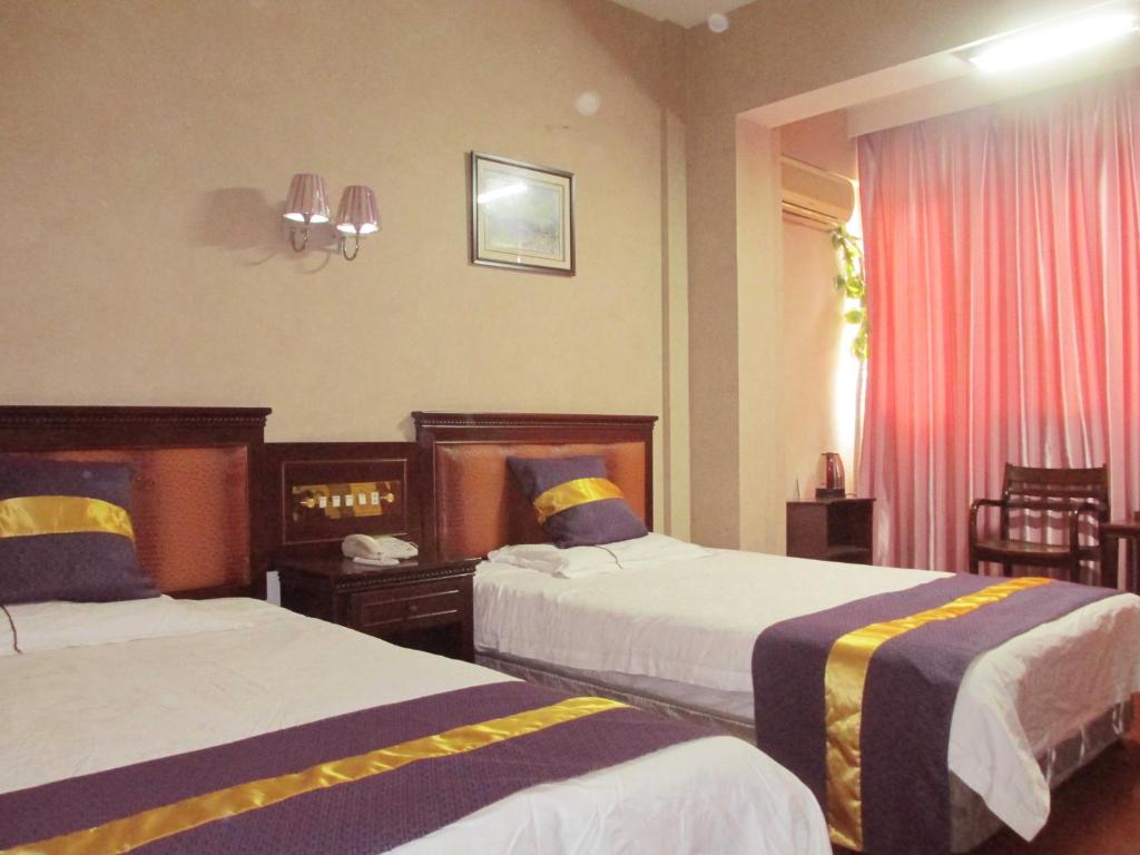 台州台山商务宾馆的酒店客房设有两张床和窗户。