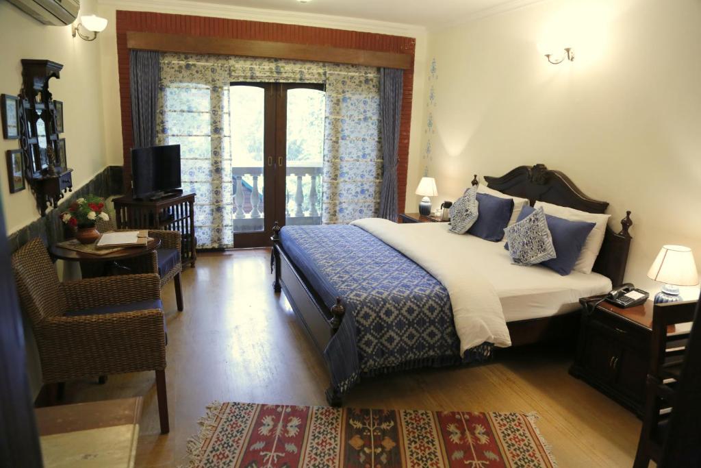 新德里伊思戴特住宿加早餐旅馆的一间卧室配有一张床、一张书桌和一个窗户。