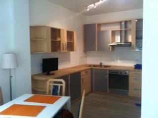 博尔扎诺博尔扎诺中心劳林公寓的厨房配有木制橱柜、桌子、桌子和桌子。