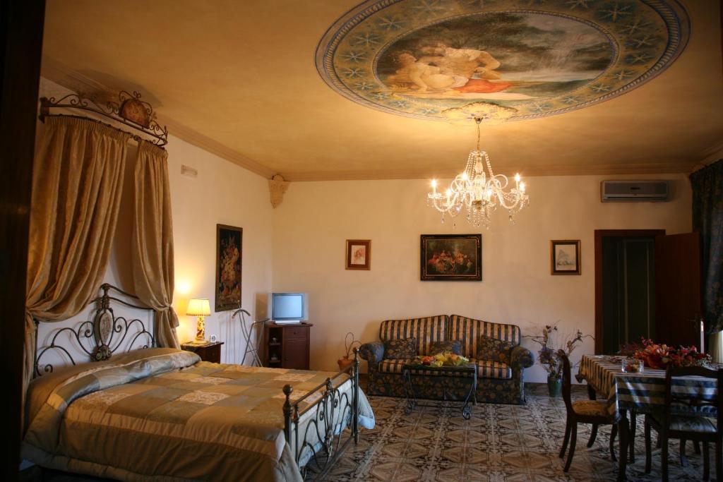 科里利亚诺多特兰托Calì Nitta的一间卧室配有一张床和一个吊灯