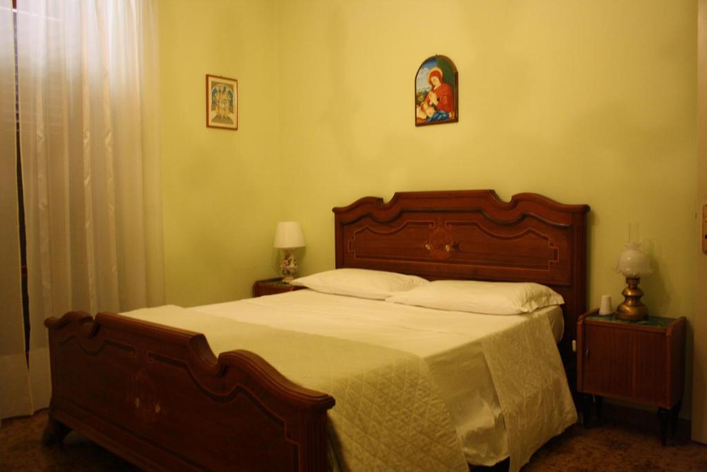 Torre le NocelleAgriturismo Casale 1921的一间卧室配有一张大床和木制床头板