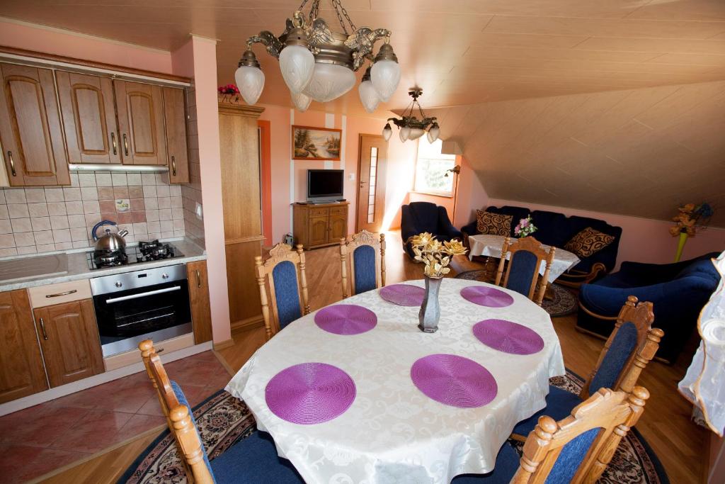 DusznicaAgroturystyka nad Jeziorem Gaładuś的厨房以及用餐室,配有带紫色盘的桌子