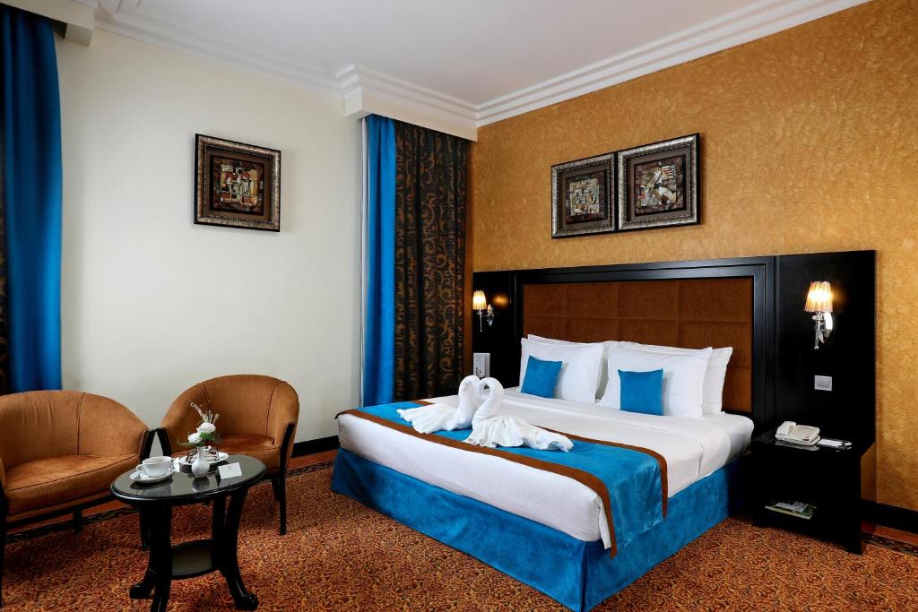 沙迦皇家豪华套房酒店的酒店客房,配有带毛巾的床