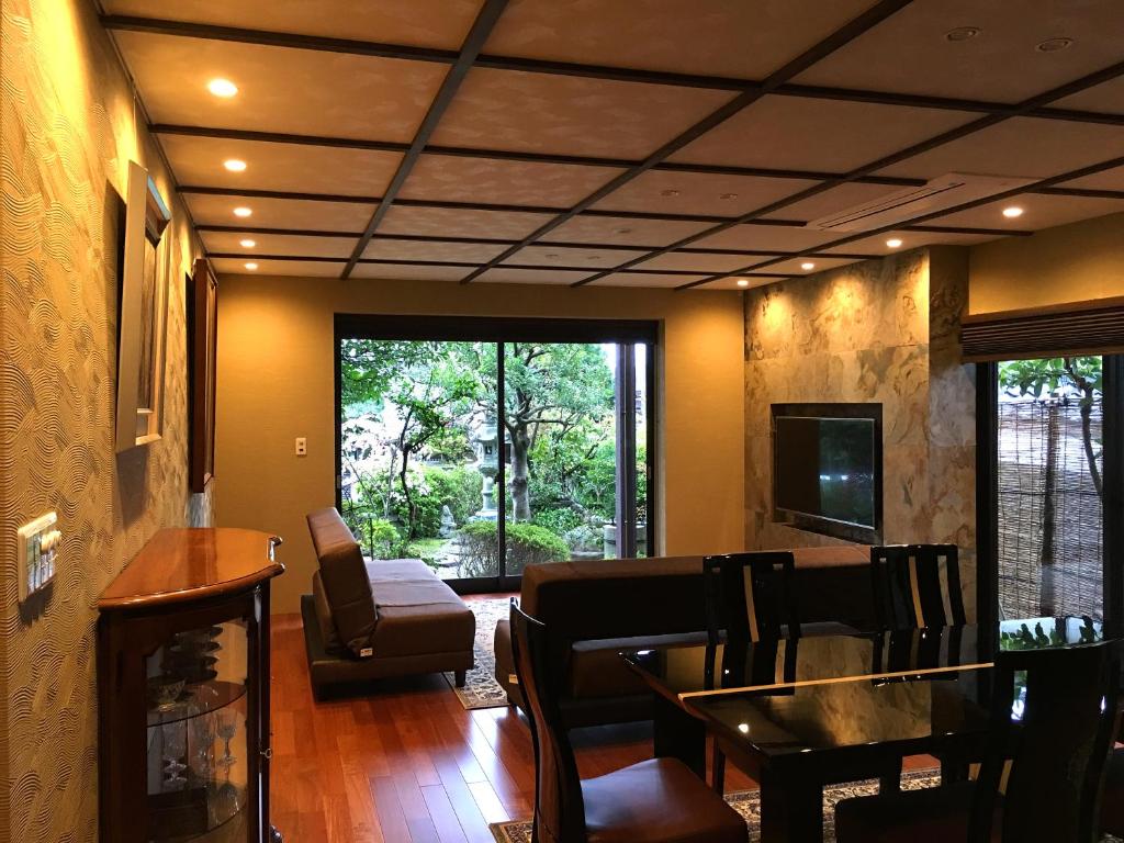 京都花之坊金阁寺道度假屋的客厅配有桌椅和电视。