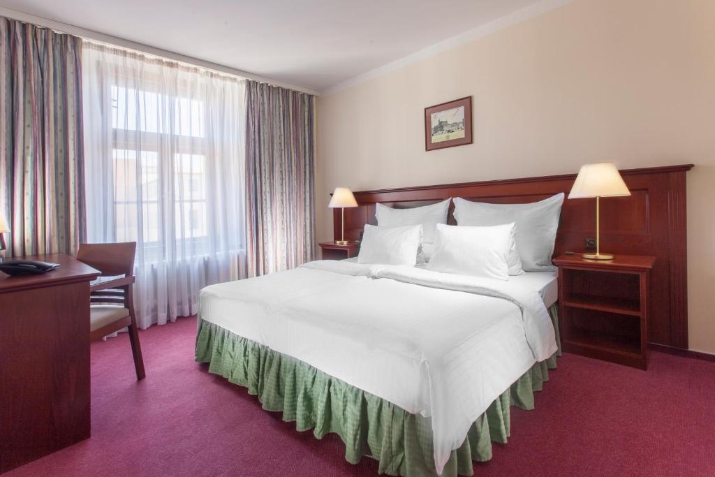 布拉格鲁尼克酒店的酒店客房设有一张白色大床和一个窗户。