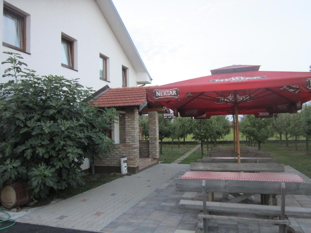 拉克塔希Pansion Laktaši的大楼前带红伞的野餐桌