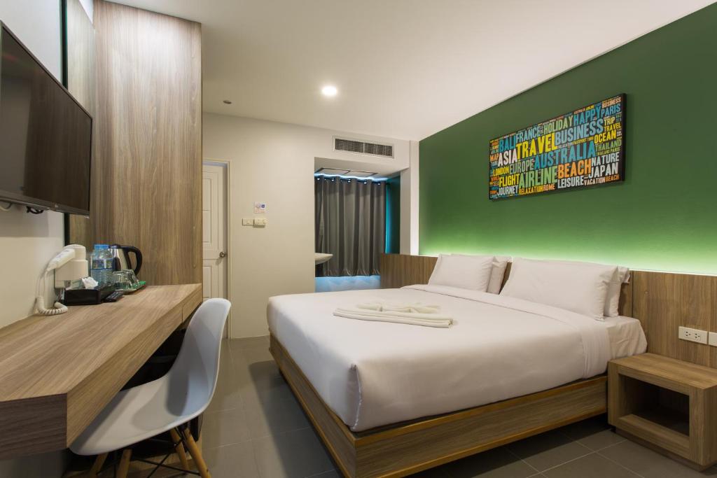 甲米镇甲米城市酒店的一间卧室设有一张大床和绿色的墙壁