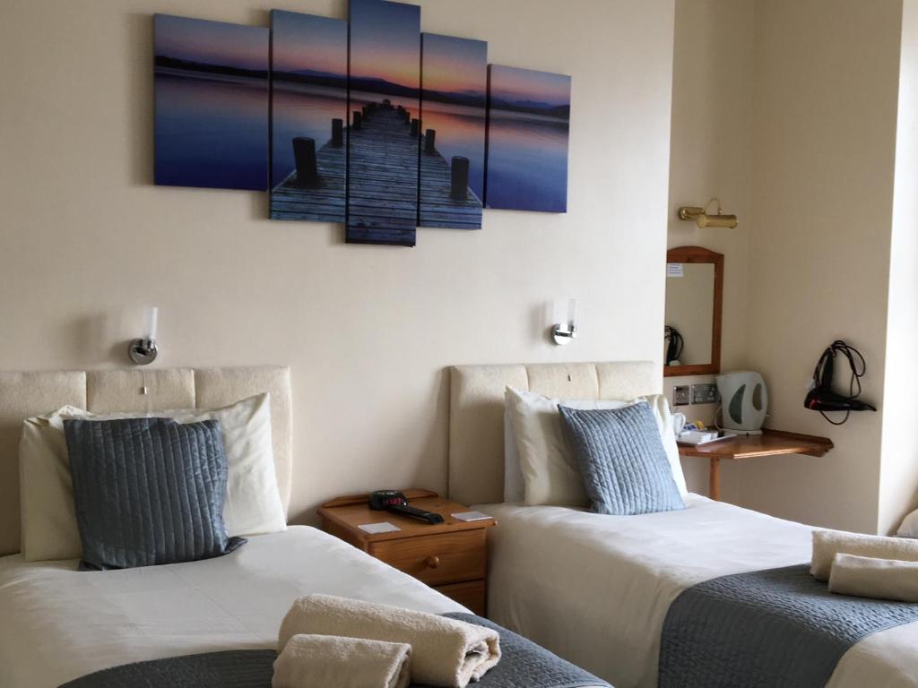 道格拉斯卡本屋旅馆的一间设有两张床的客房,墙上挂着一幅画