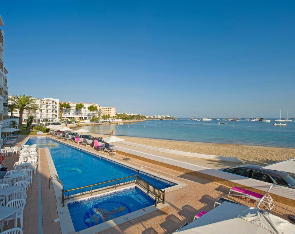 圣安东尼奥湾Hotel Vibra s'Estanyol的享有海滩旁游泳池的景色
