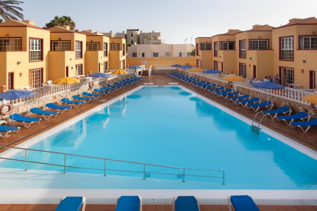 科拉雷侯马克索拉塔海滩公寓酒店的一个带椅子和遮阳伞的大型游泳池