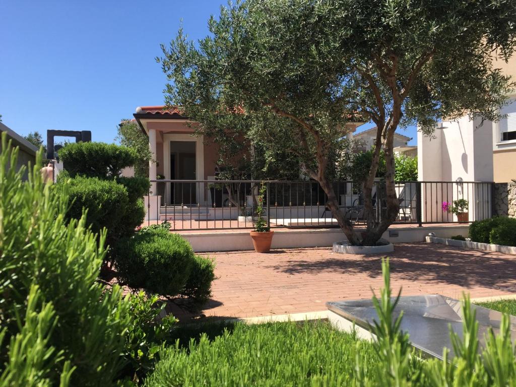 拉扎尼Villa Chiara的庭院中带庭院和树的房子