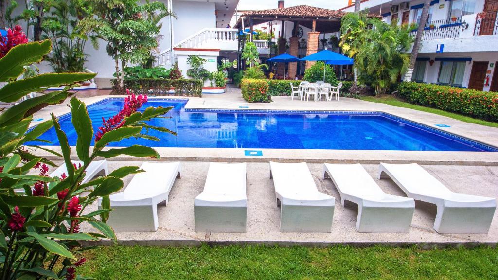巴亚尔塔港Hotel Hacienda Vallarta - Playa Las Glorias的游泳池旁设有白色躺椅