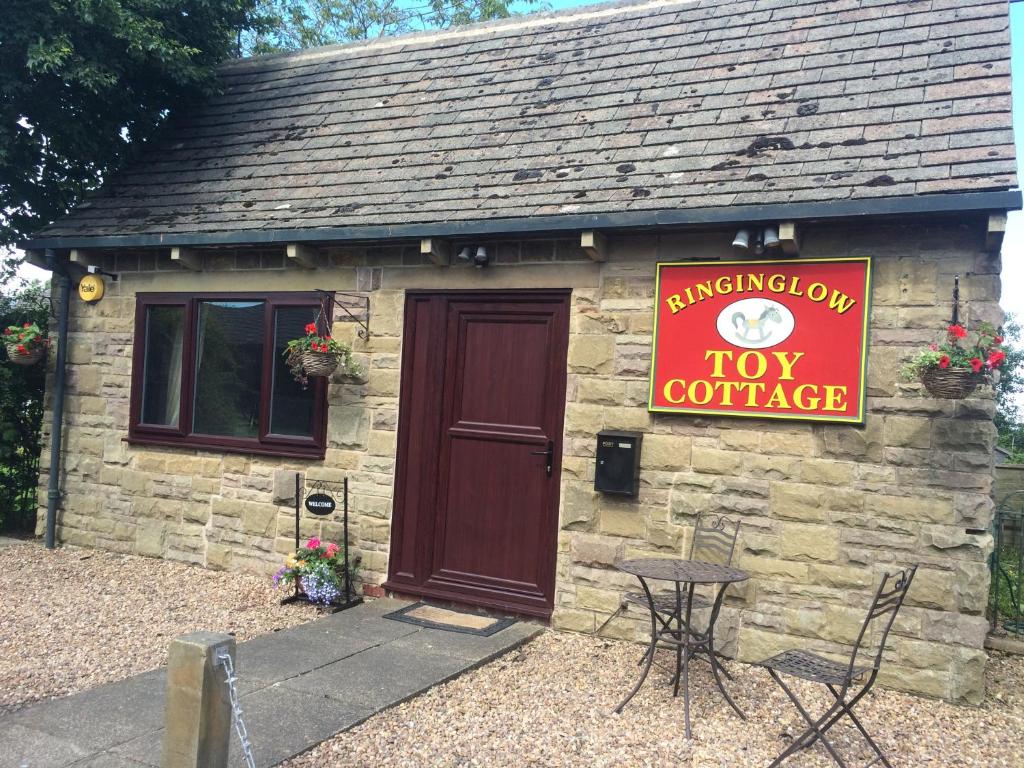 谢菲尔德Toy Cottage Sheffield的一间小小屋,上面有红色的标志