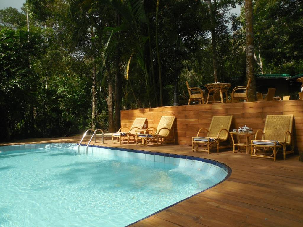 康提乐帕德爱特酒店的木制甲板上配有桌椅的游泳池