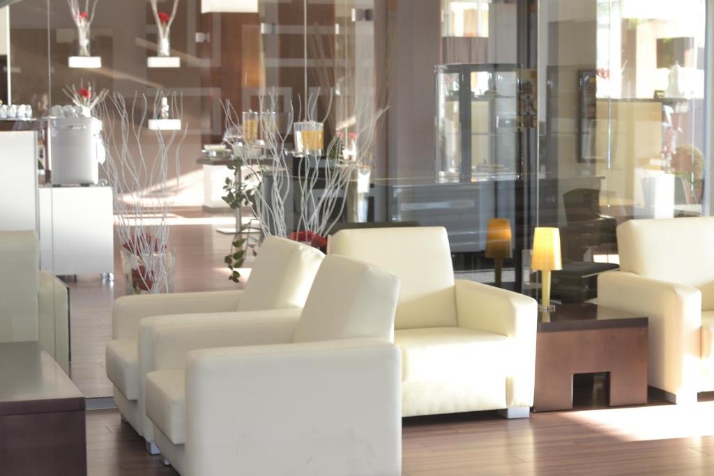 布拉迪斯拉发阿斯顿酒店的客厅配有白色的椅子和桌子