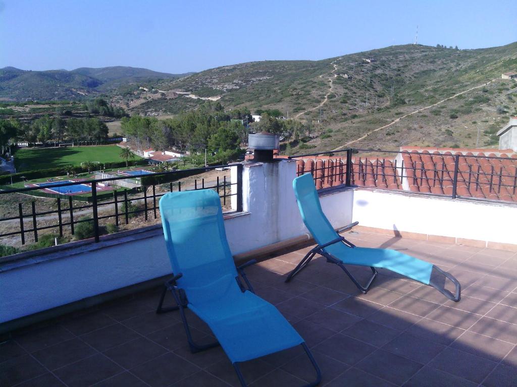 Les Coves de VinromaLa Casassa II的两把蓝色椅子坐在一个美景阳台