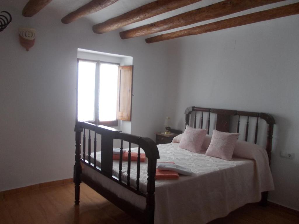 GodallCasa de pueblo Godall的一间卧室配有一张带白色床单的床和一扇窗户。