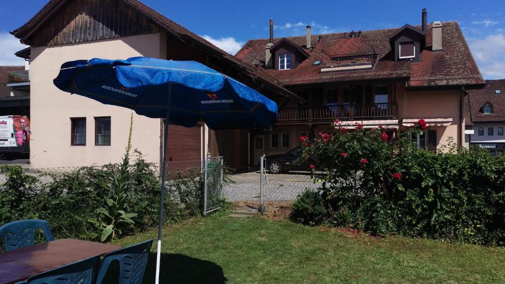 Cheseaux金皮特博纳尔旅馆的房子院子中的一把蓝色雨伞