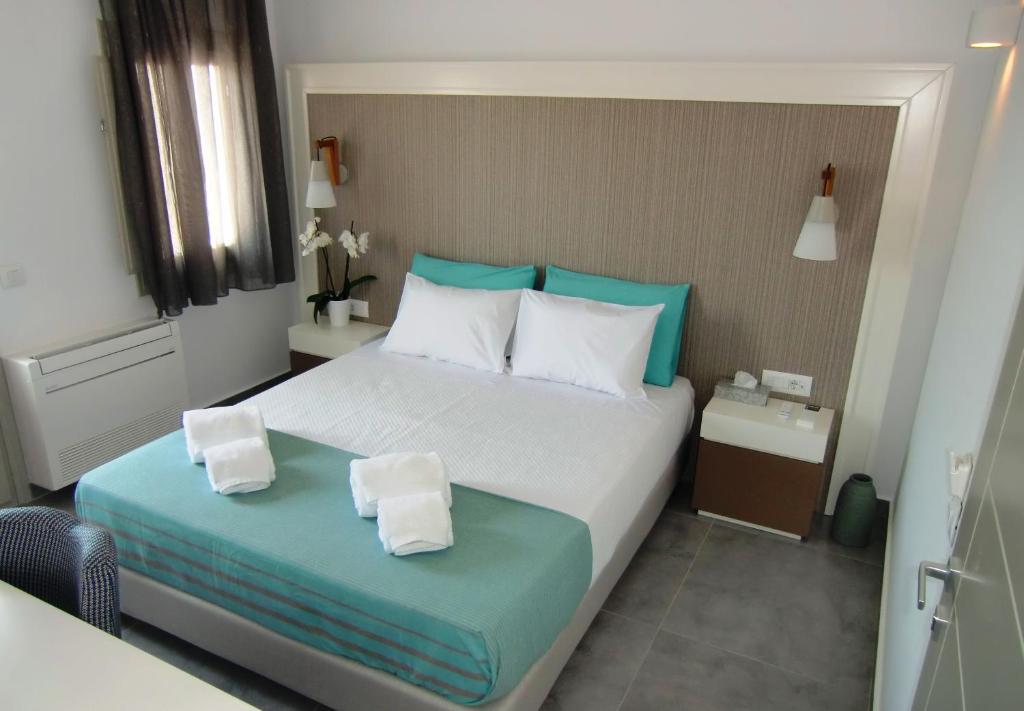 费拉Platia的一间卧室配有一张带蓝色和白色枕头的床