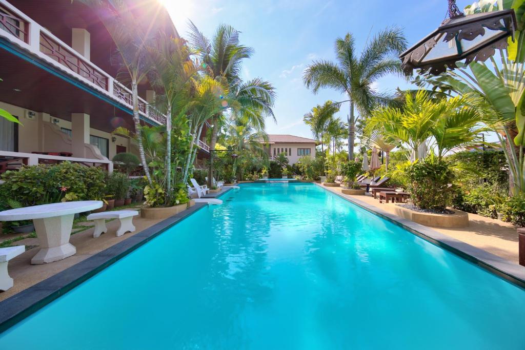 拉迈欧姆派豪华酒店的拥有蓝水和棕榈树的度假村的游泳池