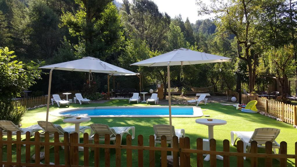 圣洛伦索-德莫鲁尼斯Cal Mosqueta的后院设有带椅子和遮阳伞的游泳池