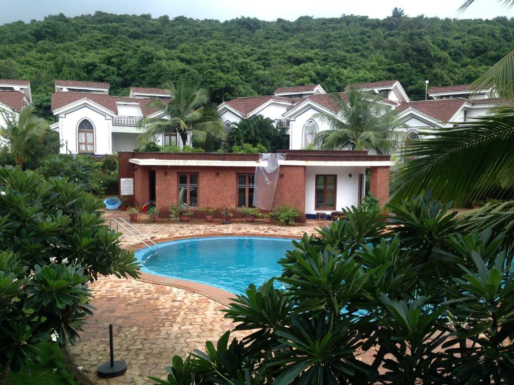 阿伯来Pool and Garden Facing Apartment in Riviera Foothills Near Baga, Arpora的享有带游泳池的房子的景色