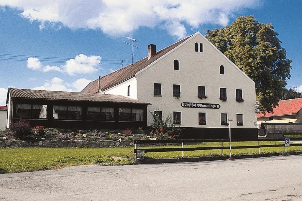 多瑙河畔韦尔特Gasthof Pflamminger的白色的建筑,旁边标有标志
