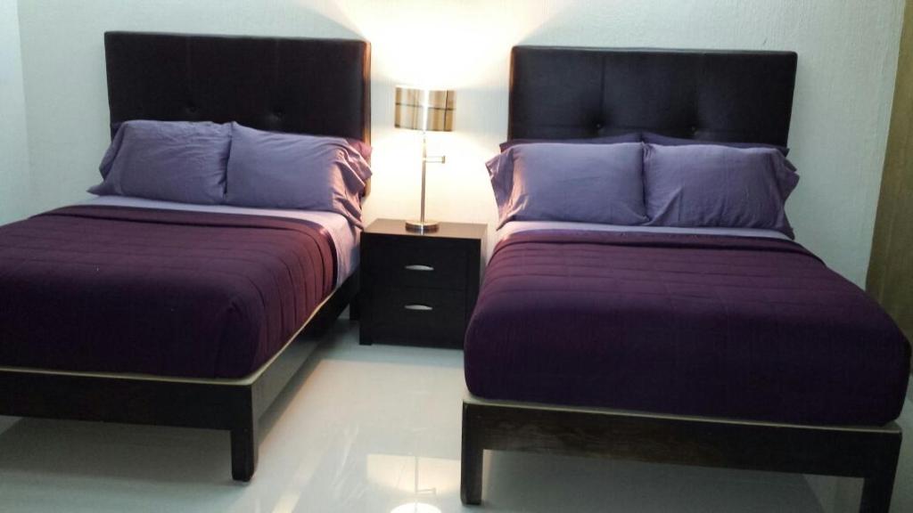 奥夫雷贡城Premier Hotel Suites的两张睡床彼此相邻,位于一个房间里