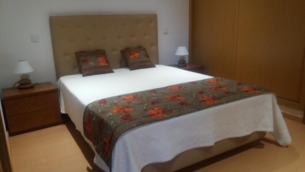 CortelhaCasa De Campo Cantinho Da Serra的一间卧室配有一张白色大床,床上有鲜花