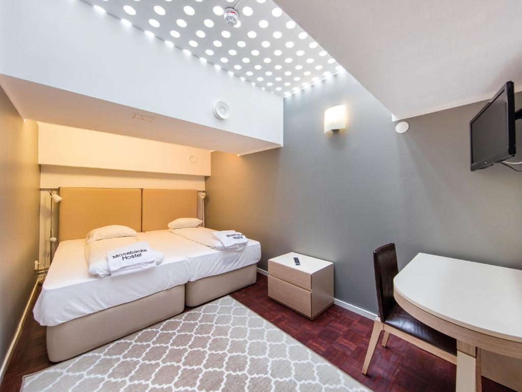 斯德哥尔摩莫斯贝克旅馆的小房间设有床、书桌和水槽