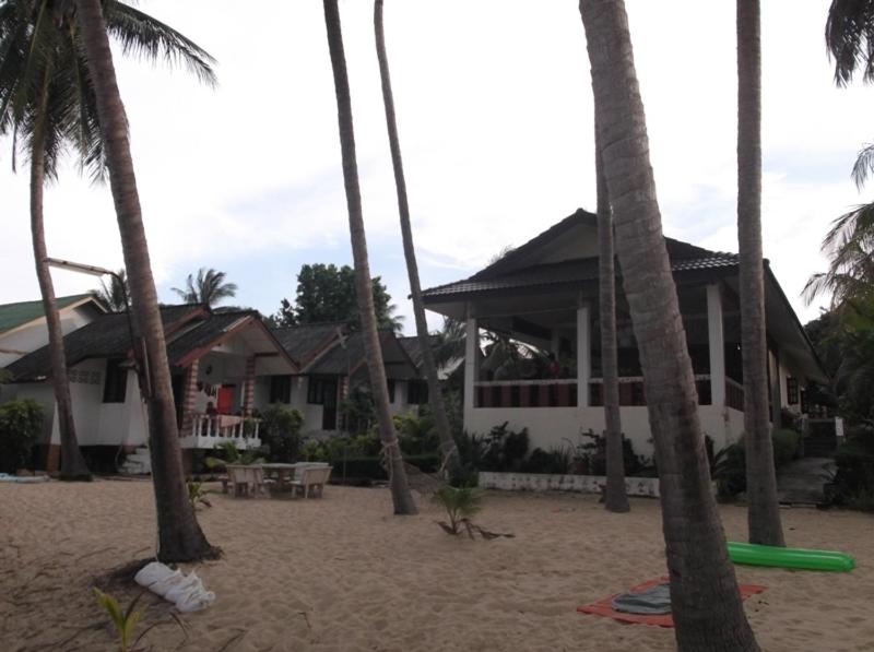 湄南海滩棕榈波特乡村酒店的棕榈树海滩上的房子