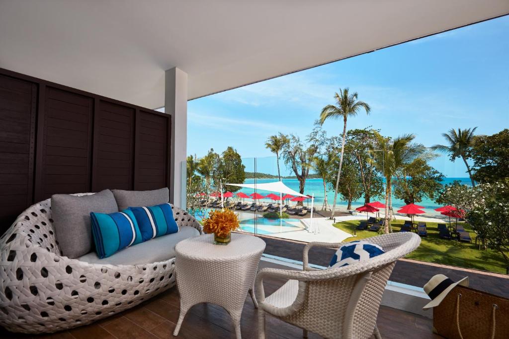 查汶苏梅岛阿玛瑞度假酒店的一个带沙发和椅子的庭院,享有游泳池的景色