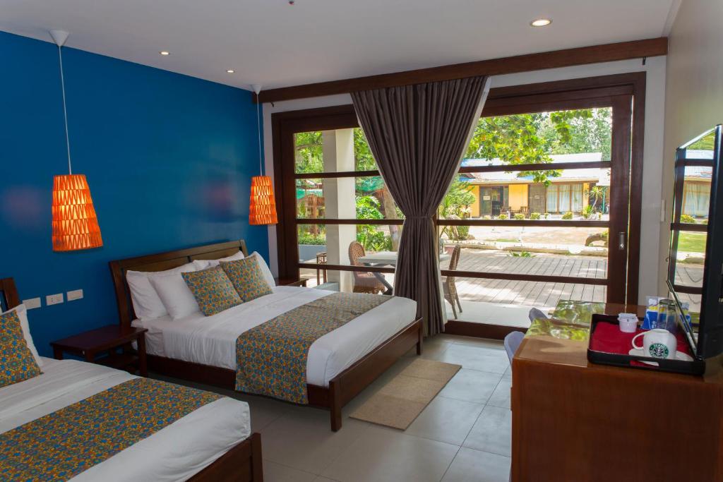 麦克坦卡兰屈海滨旅馆的酒店客房设有两张床和窗户。