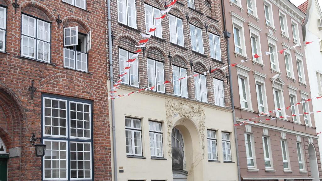 吕贝克Apartments im Einhornhaus的砖砌的建筑,上面有红白的旗帜
